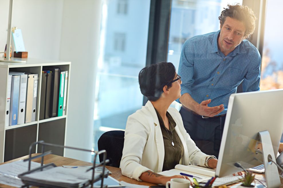 Colleges at a desk with Monitor are in a discussion